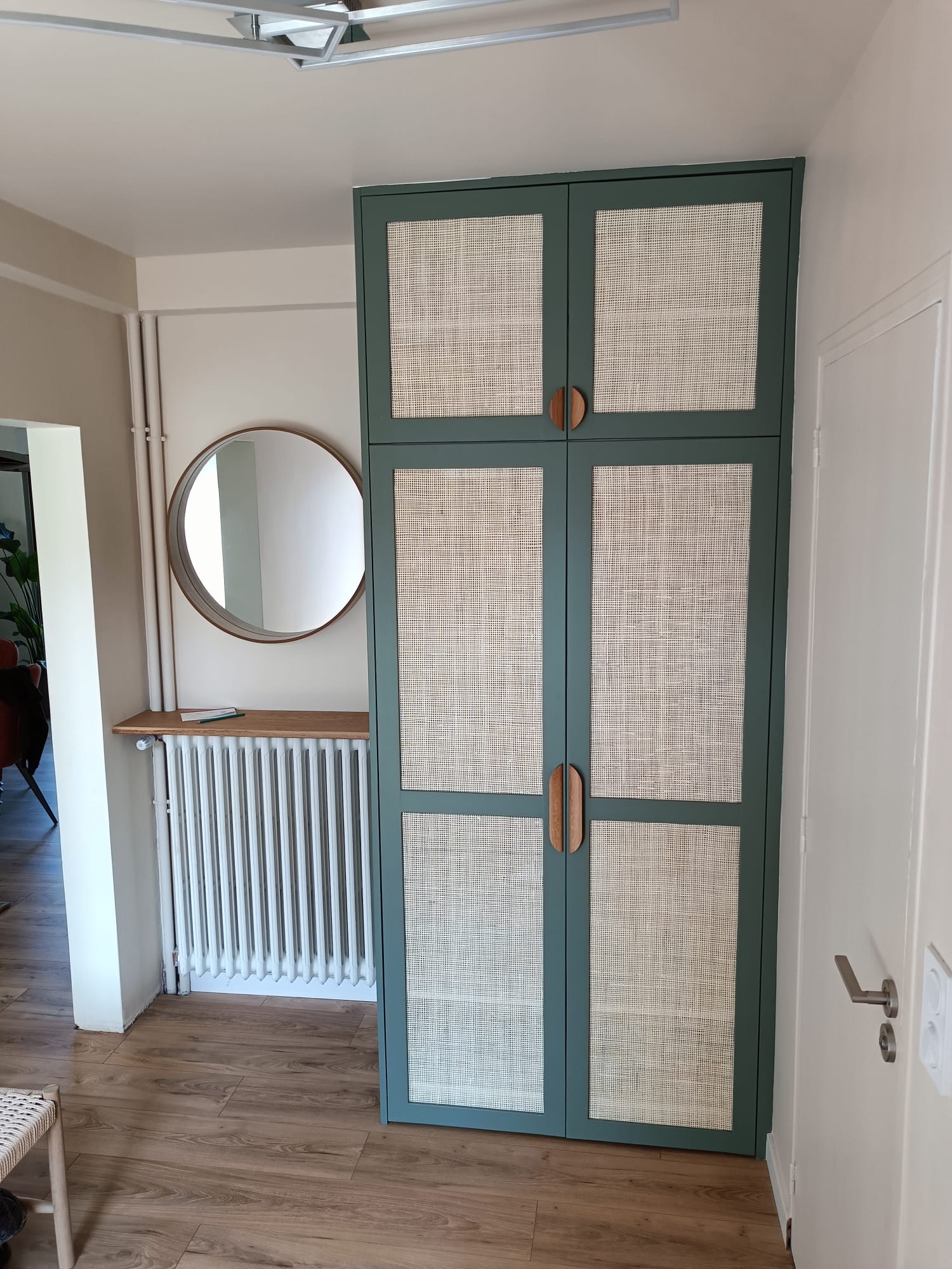 Penderie d'entrée : portes en hêtre peintes avec cannage naturel. Poignées et tablette sur radiateur en chêne par Hugo Pauchard - HP Bois Menuiserie - Saint-Malo
